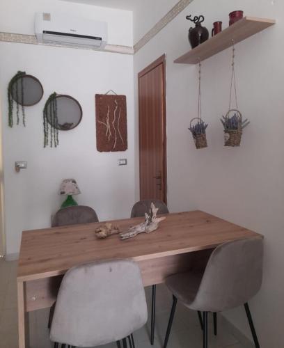 a wooden table with two chairs in a room at Tra Vento e Mare in Lendinuso