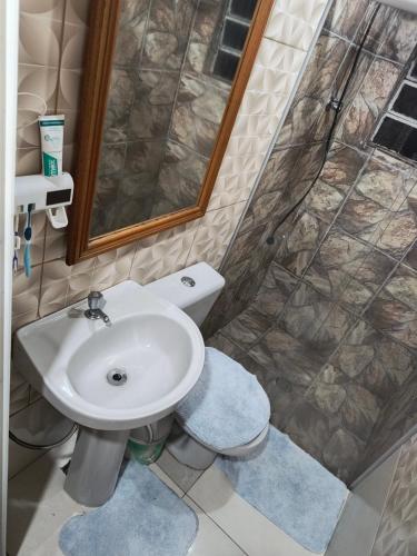 a bathroom with a toilet and a sink and a shower at Flores da vovó in Campos do Jordão