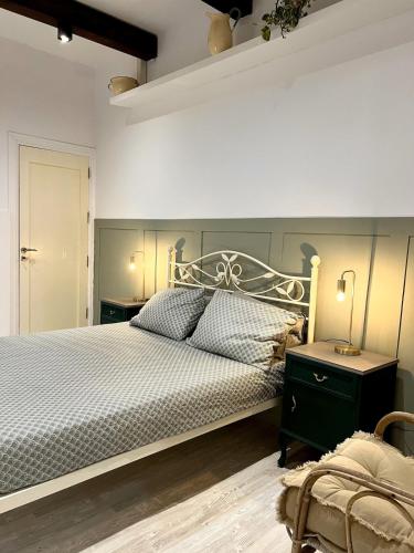 a bedroom with a large bed and a lamp on a table at Dar Il-Ħnejja - Character Home close to Valletta in Il-Furjana