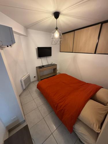 une petite chambre avec un lit et une télévision dans l'établissement Magnifique 2 pièces en plein centre de Cannes à côté des plages, à Cannes