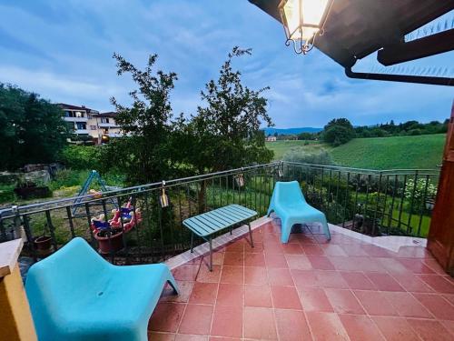 a balcony with two blue chairs and a fence at Blackland- Shabby Tuscany House in Colle Val D'Elsa