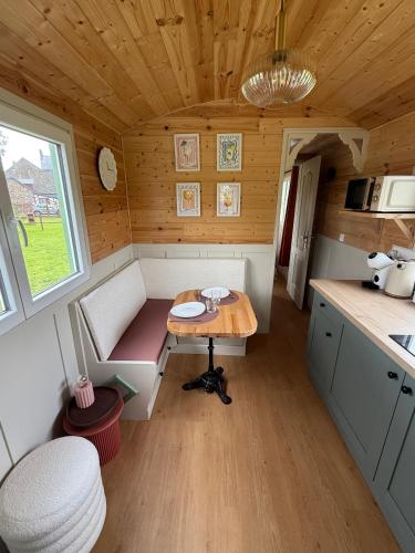 - une petite cuisine avec une table dans une petite maison dans l'établissement La Roulotte de Ville Chérel, à Pontorson