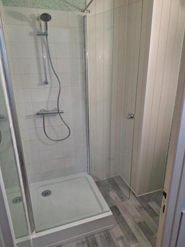 une douche avec une porte vitrée dans une salle de bain dans l'établissement Appartement - 4 personnes - Saint-Hilaire-de-Riez, à Saint-Hilaire-de-Riez