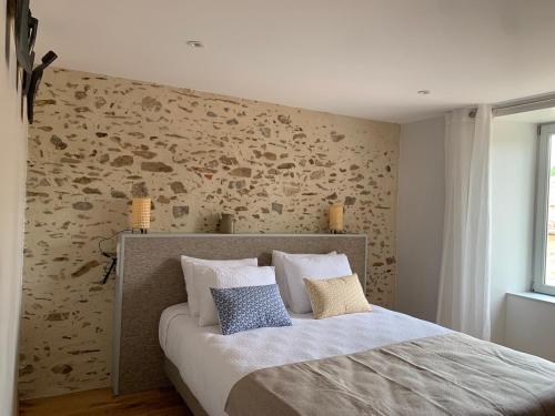 une chambre avec un lit avec deux oreillers dessus dans l'établissement Le Moulin des Etrebières, à Cheffois