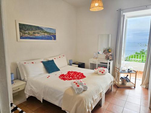 a bedroom with a bed with red flowers on it at Villa Bina Sea Hotel in Ischia