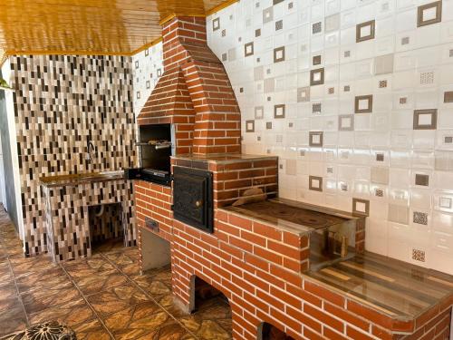 a brick oven in a room with a brick wall at Recanto da Valentina in Campos do Jordão