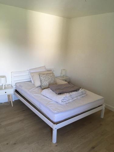 Ce lit se trouve dans un dortoir doté d'un mur blanc. dans l'établissement Le village caché, à Mayet-de-Montagne