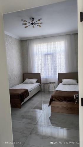 a bedroom with two beds and a ceiling fan at White House gabala 