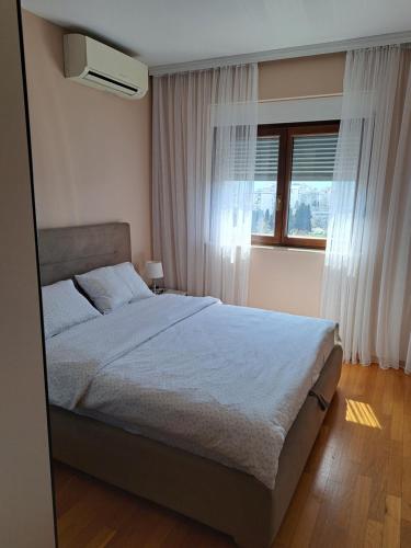 a bedroom with a large bed and a window at Stan u centru BEST VIEW in Bar
