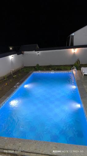 a large blue swimming pool at night at White House gabala 