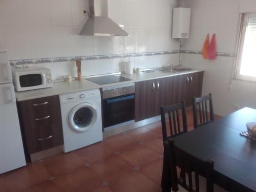 cocina con lavadora y microondas en Apartamento Peralbar, en Carnota