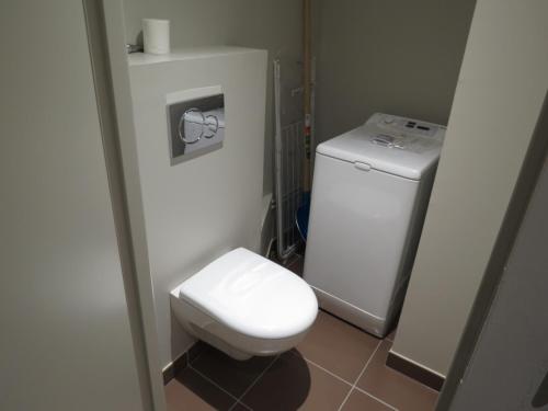 La petite salle de bains est pourvue de toilettes blanches et d'un lavabo. dans l'établissement Appart 8 Personnes avec Salon Neuf et Parking Couvert Le Thuria, à Bourg-Saint-Maurice