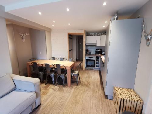 Il comprend un salon et une cuisine avec une table et des chaises. dans l'établissement Appart 8 Personnes avec Salon Neuf et Parking Couvert Le Thuria, à Bourg-Saint-Maurice
