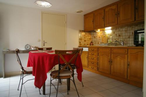 una cucina con tavolo e panno rosso di Juniper House a Vulaines-sur-Seine