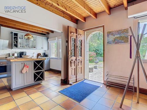 une cuisine avec une porte s'ouvrant sur une cuisine avec un comptoir dans l'établissement Ty Lora - Isolée en bord de mer, à Telgruc-sur-Mer