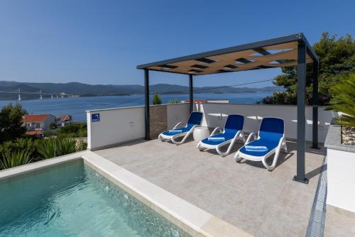 a group of chairs sitting next to a swimming pool at Villa Mare in Klek