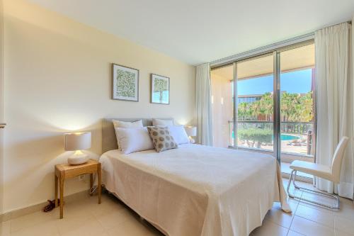 a white bedroom with a bed and a large window at Entre o Vale e o Mar - Herdade dos Salgados in Guia