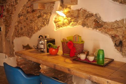 une table en bois avec deux chaises bleues et une table avec des tasses dans l'établissement Vale's Gardens at Borgio Verezzi, à Borgio Verezzi