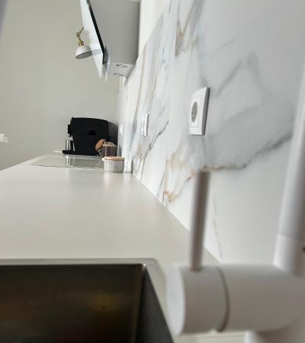 a kitchen with a white counter top and a sink at Dania Home Noia in Noya