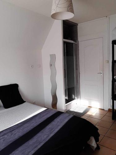 une chambre avec un lit et un mur blanc dans l'établissement Sea and Sun 3, à Berck-sur-Mer