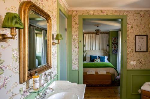 a bathroom with a bed and a sink and a mirror at Rosegarden Essence Sintra AL - by Unlock Hotels in Sintra