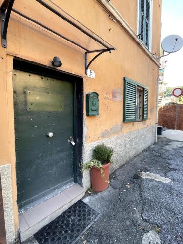 a garage with a green door on the side of a building at Tranquillità a Sori in Sori
