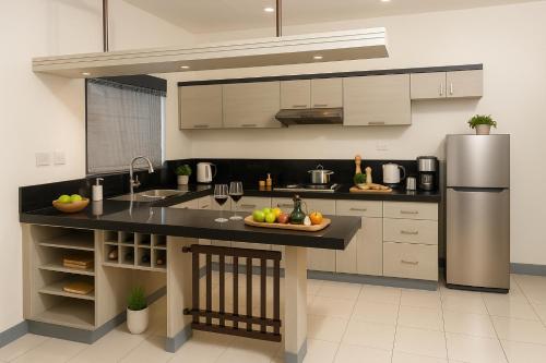 a kitchen with a refrigerator and a plate of fruit on a counter at Queen room only near sm mall Fast Wifi in Malabañas