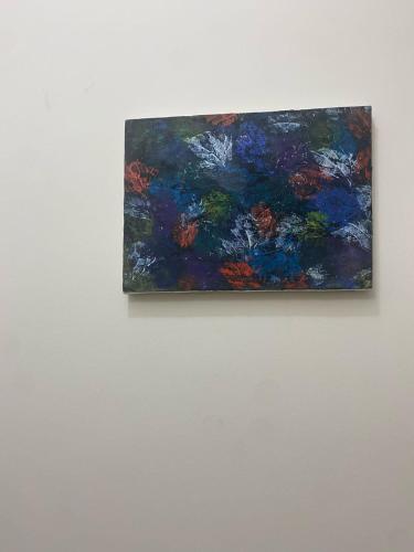 a painting is hanging on a white wall at Home Stay Mtsbd in Dhaka