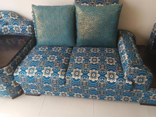 a couch with blue and white pillows on it at Home Stay Mtsbd in Dhaka