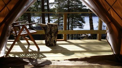 a porch with a bench and a tree stump at Sälstationen - The seal station 