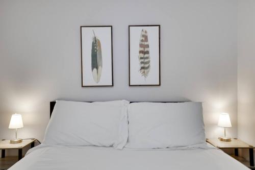 a bedroom with a white bed with three pictures on the wall at Close to Hospitals with W&D Free Parking Fast Wifi in Wilkes-Barre