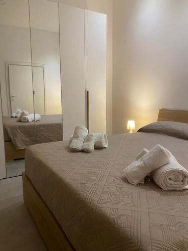 a bedroom with a bed with towels and a mirror at Il Cortiletto Casa Vacanze in Pachino