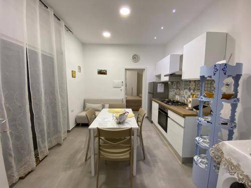 eine Küche und ein Esszimmer mit Tisch und Stühlen in der Unterkunft Il Cortiletto Casa Vacanze in Pachino