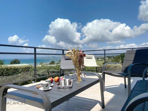 une table avec un vase de fleurs sur un balcon dans l'établissement Maison de Porz Iroise (Vue Mer), à Plomodiern