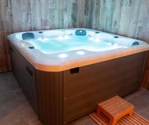 La salle de bains est pourvue d'une grande baignoire et d'un mur en bois. dans l'établissement Cocon landais entre piscine et océan, à Onesse-et-Laharie