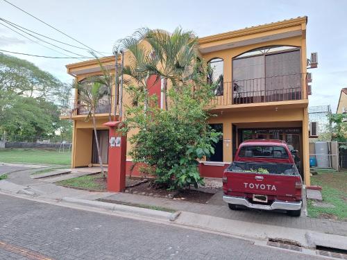 an old red truck parked in front of a house at Villa Prados del Rio - Guanacaste, Costa Rica in Comunidad
