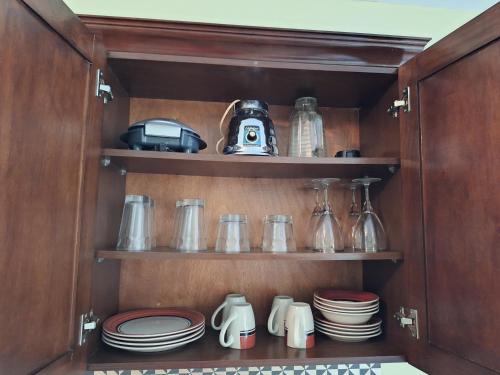 a cupboard filled with plates and utensils at Villa Prados del Rio - Guanacaste, Costa Rica in Comunidad