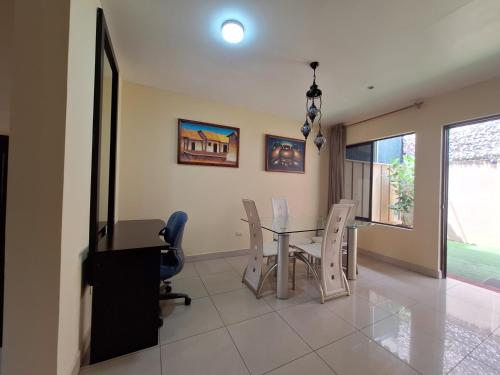 a dining room with a glass table and chairs at Villa Prados del Rio - Guanacaste, Costa Rica in Comunidad