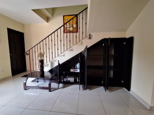a living room with a staircase and a table at Villa Prados del Rio - Guanacaste, Costa Rica in Comunidad