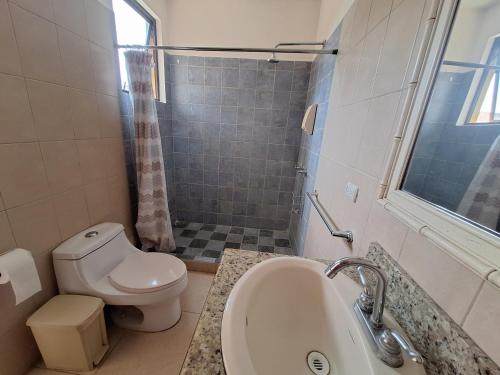 a bathroom with a toilet and a sink and a shower at Villa Prados del Rio - Guanacaste, Costa Rica in Comunidad