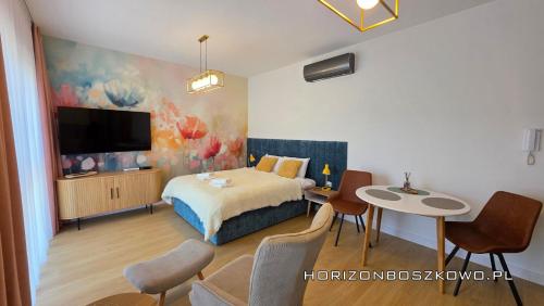 ボシュコボにあるBoszkowo Horizon Park Apartament 14 "Laguna"のベッドとテーブルと椅子のある寝室