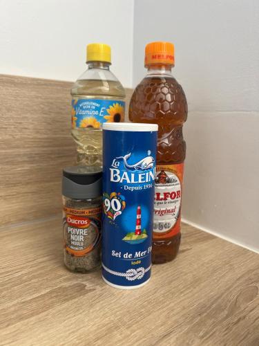 three bottles of peanut butter and jelly sitting on a floor at LE FAMILIAL 6 PERSONNES WIFi PARKING in Bébing