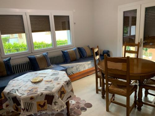 a living room with a table and a couch at Appartement 4 pièces dans une maison au calme in Bonneville