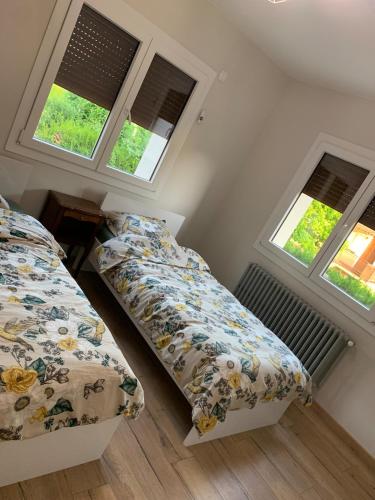 une chambre avec deux lits et deux fenêtres dans l'établissement Bonneville Accommodation, à Bonneville