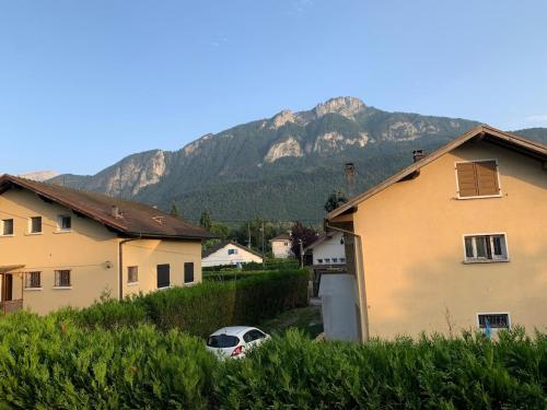 a house and a car parked in front of a mountain at Appartement 4 pièces dans une maison au calme in Bonneville