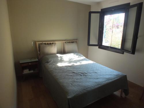 une petite chambre avec un lit et une fenêtre dans l'établissement maison tranquille en Provence, à La Celle-sous-Gouzon