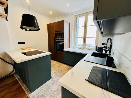 une cuisine avec un comptoir noir et blanc dans l'établissement Le QUIET duplex, hypercenter, 2 bedrooms, spacieux, à Tours