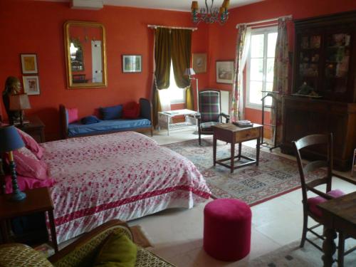 a bedroom with orange walls and a bed and a table at LOGIS du Château du Bois Doucet in Bignoux