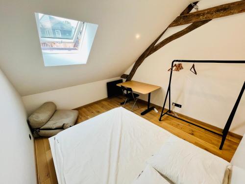 Cette chambre mansardée comprend un lit et un bureau. dans l'établissement Le QUIET duplex, hypercenter, 2 bedrooms, spacieux, à Tours