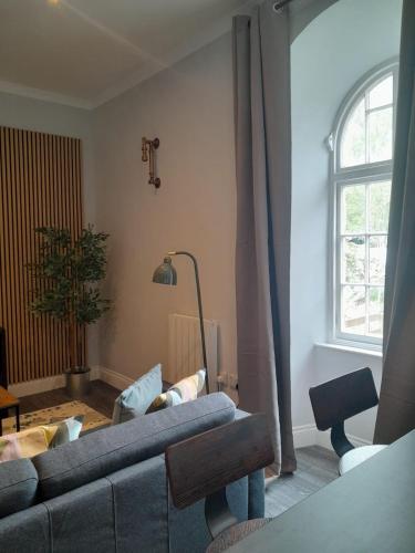 a living room with a couch and a window at Outlander 4 Apartment Doune in Stirling